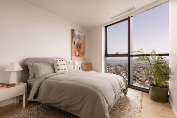 A bedroom with a large bed and a view of the city.