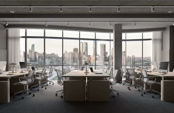 an open office with desks and chairs and a city view