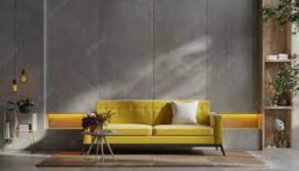 A yellow sofa with a white pillow is in front of a grey wall.