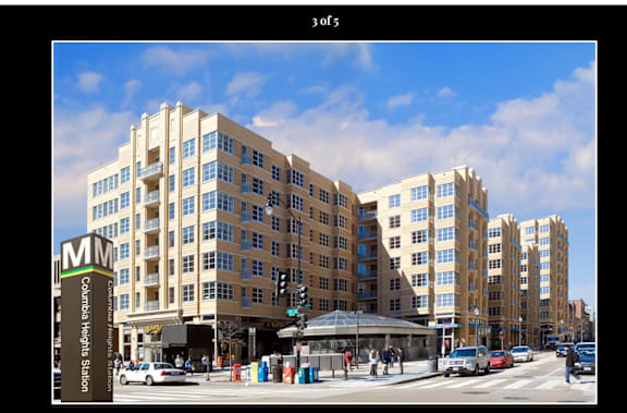 A street view of a city with a large building in the background and a street sign that says Columbia Tech Plaza.