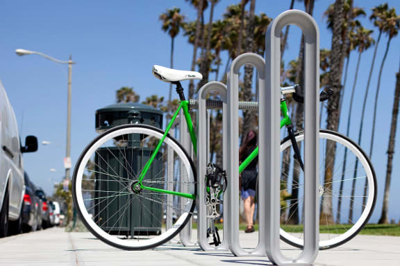 Alt - Olympia Bike Racks shown with Aluminum Texture powdercoat with green bike attached to it