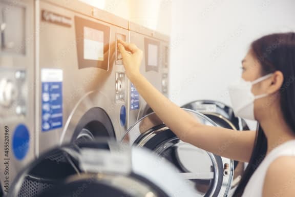 Alt-A girl usign washer and dryer in an apartment