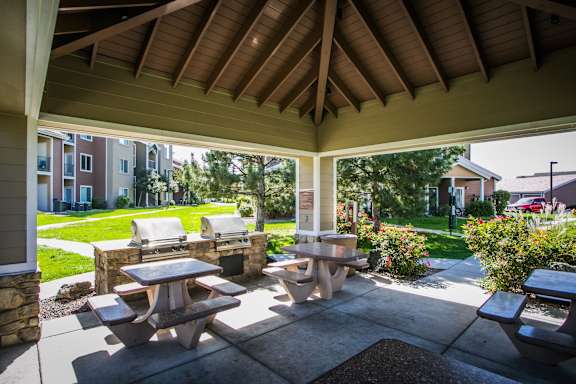A patio with a table and chairs is covered by a roof.