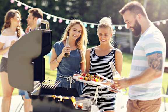 A group of people are gathered around a barbecue grill.