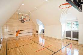 a boy is playing basketball in a large room with a basketball hoop