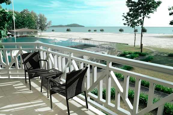 A white railing with chairs and tables on it.