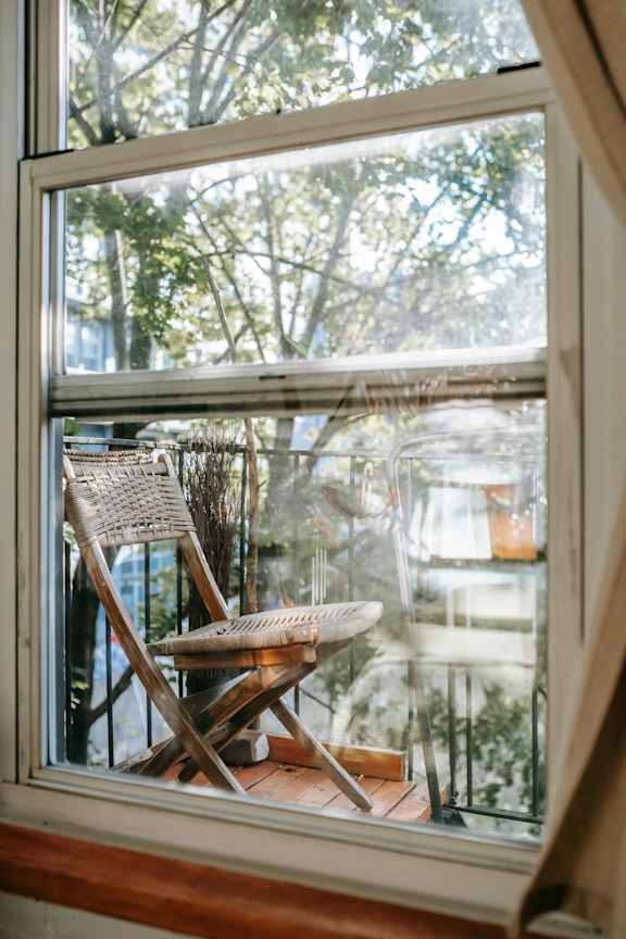 A chair is placed in front of a window.