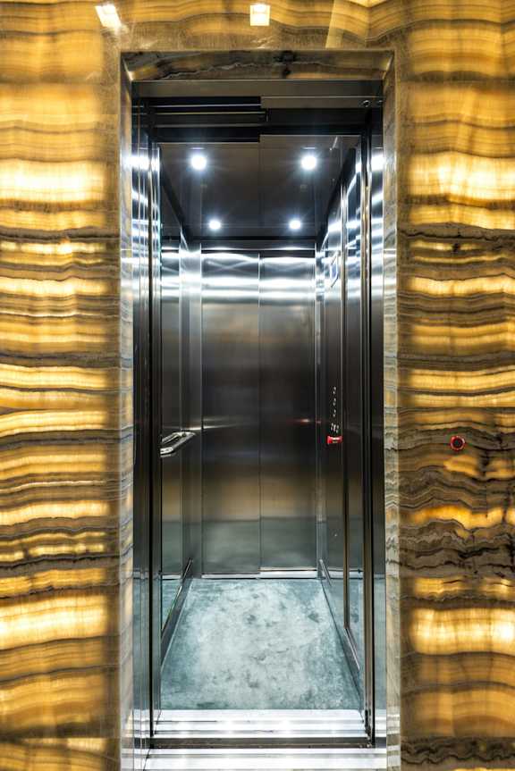 A modern elevator with a glass door and a metallic frame.