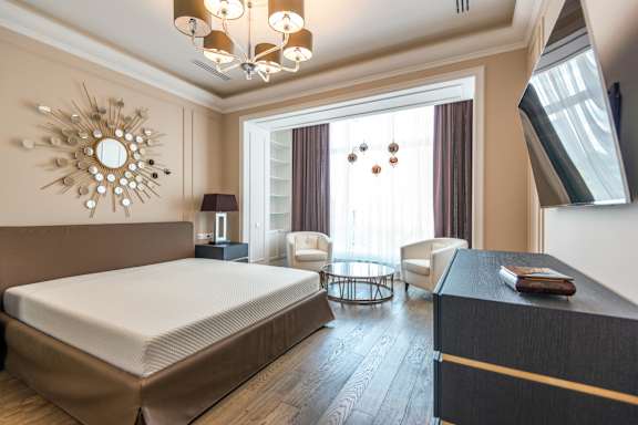 A bedroom with a large bed and a mirror on the wall.