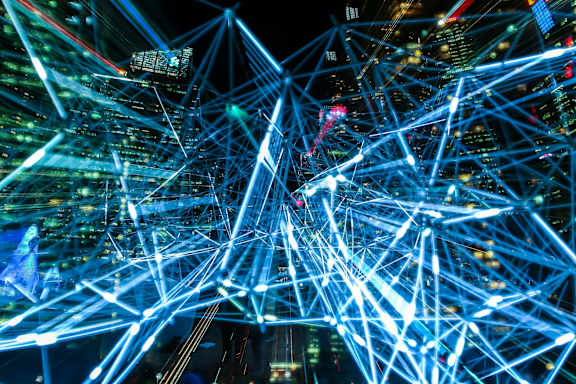A network of blue neon lights over a cityscape at night.