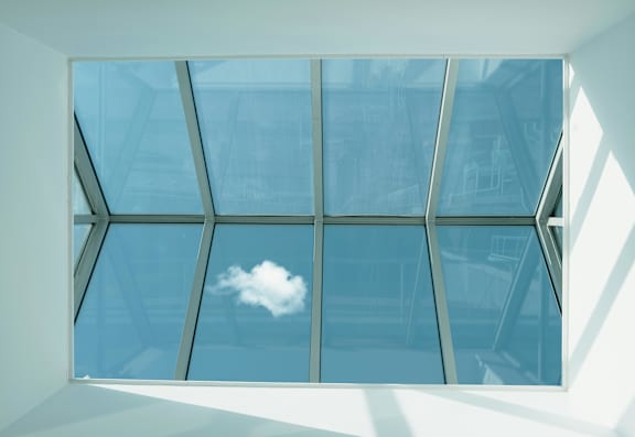 A window with a view of a cloud in the sky.