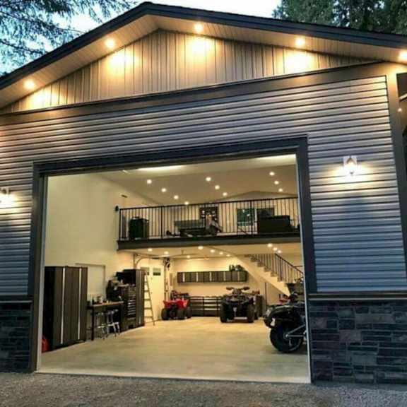 A modern house with a garage that has a motorcycle and a lawn mower inside.