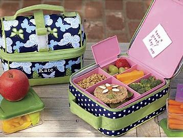 A pink lunch box with a label that says "Kate" on it.