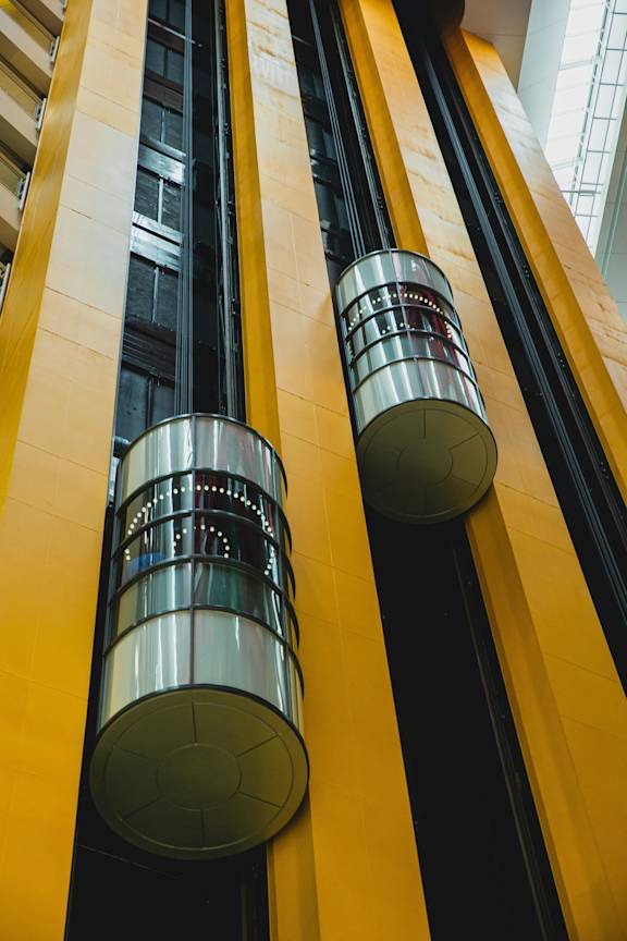 Two cylindrical objects with a pattern on them are attached to a yellow wall.