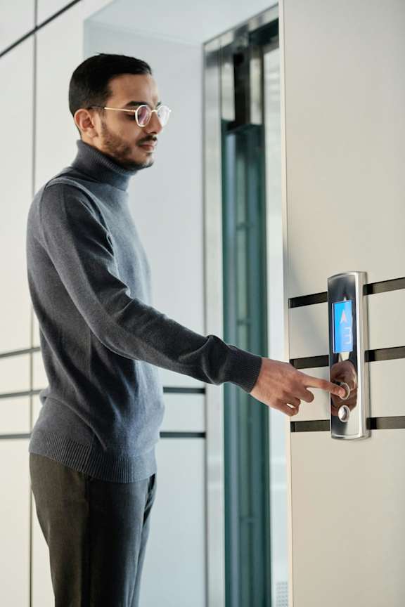 A man is using a touchless sensor to open a door.