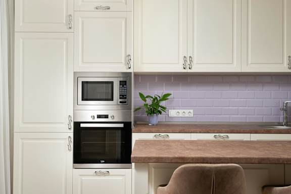 A modern kitchen with a stainless steel oven and microwave.