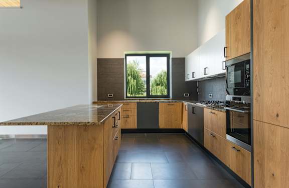 A modern kitchen with wooden cabinets and a granite countertop.