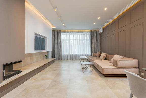 A modern living room with a fireplace and a large couch.