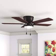 A ceiling fan with a light hanging from the ceiling in a room with a window and a painting on the wall.