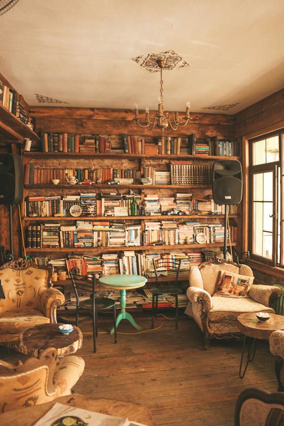 A cozy room filled with books and furniture.