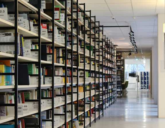 A library aisle with books on shelves numbered from 2.3 to 30.1.