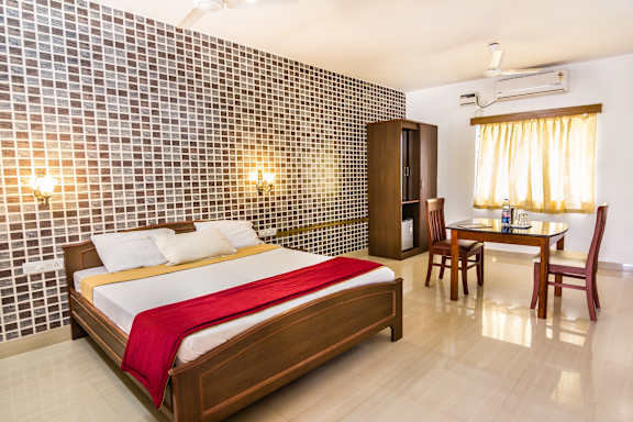 A bedroom with a bed, a table, and chairs.