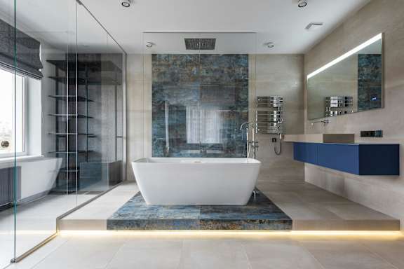 A modern bathroom with a large tub and a glass shower.