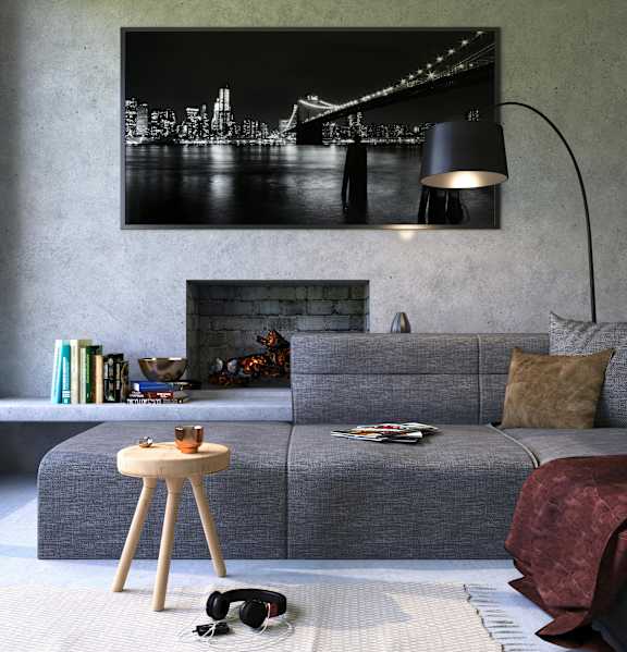 A grey couch with a lamp and a picture on the wall.
