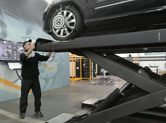 A man is working on a car in a garage.