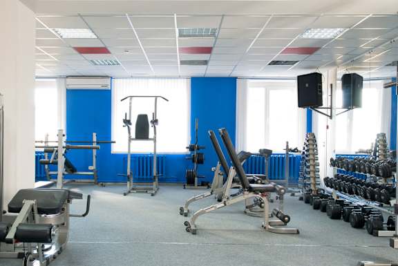 A gym with blue walls and various exercise equipment.