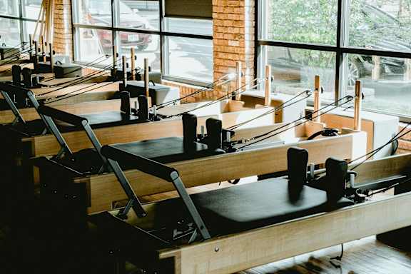 A room with a row of pilates reformers.