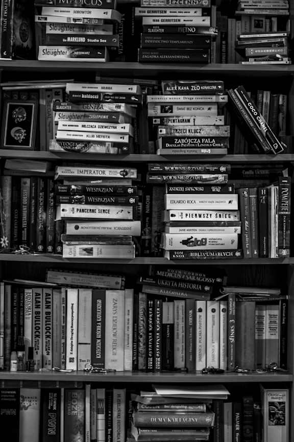 A black and white photo of a bookshelf filled with books.