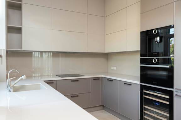 A modern kitchen with a white countertop and a black oven.