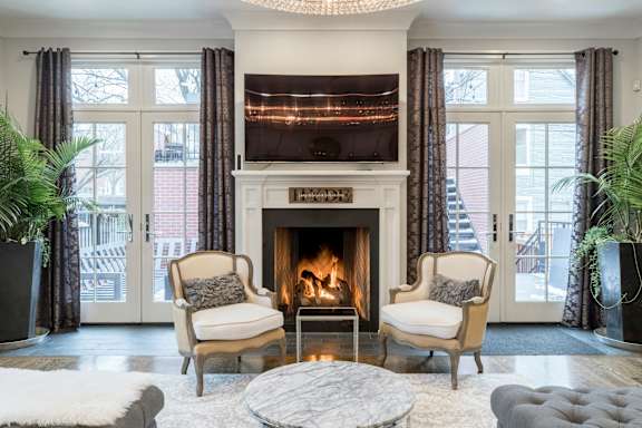 A living room with a fireplace and two chairs.