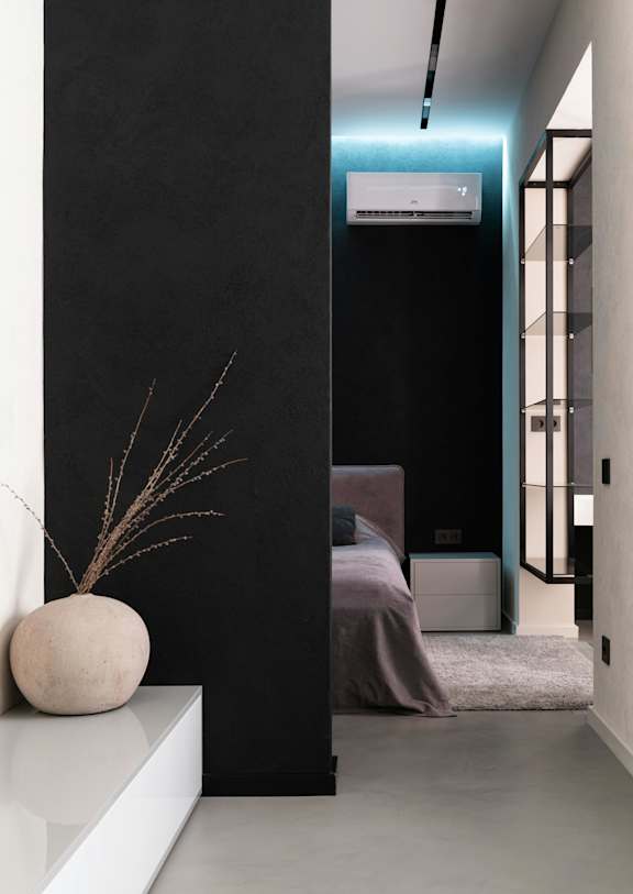 A modern bedroom with a large bed and a white vase on a shelf.