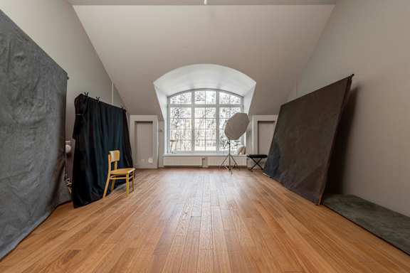 A room with wooden floors and a large arched window.