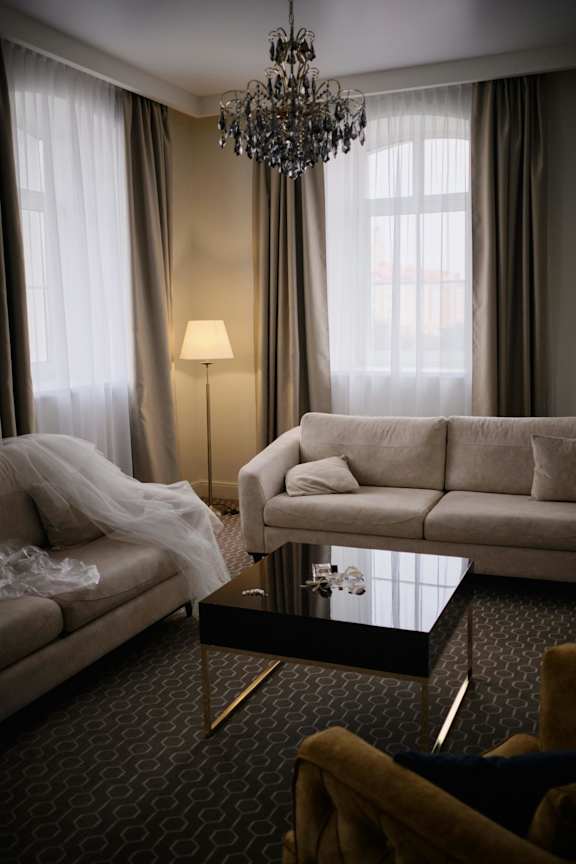 A living room with a couch, a chair, a coffee table, and a chandelier.