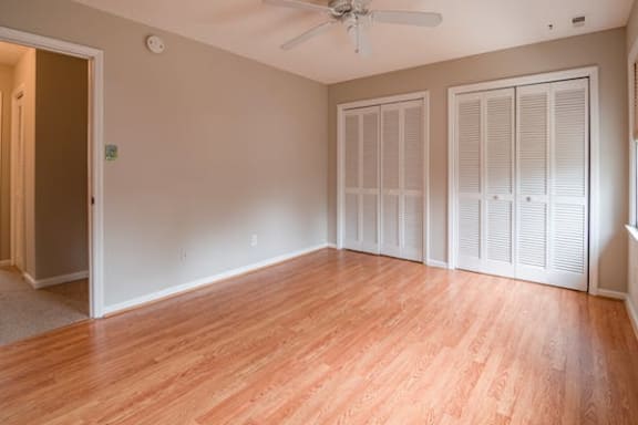 an empty room with a ceiling fan and closet