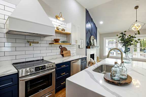 A modern kitchen with a white countertop and blue cabinets.