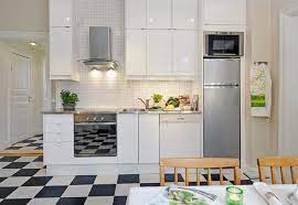 a white kitchen with a black and white checkered floor