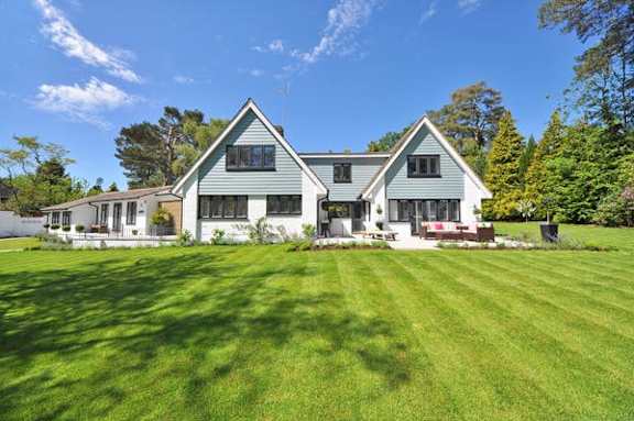 A large house with a green lawn in front.
