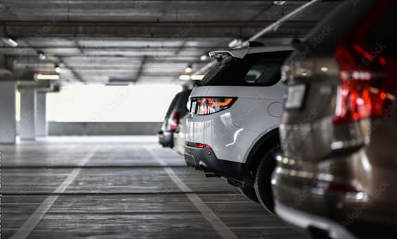 A white car is parked in a parking garage.
