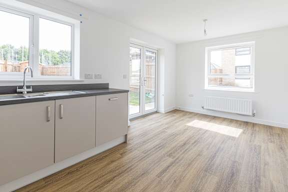 A kitchen with white cabinets and a wooden floor.