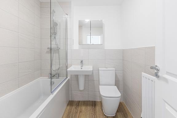 A white bathroom with a toilet, sink, and bathtub.