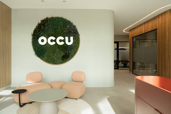 A modern living room with a green plant wall and a white sofa.