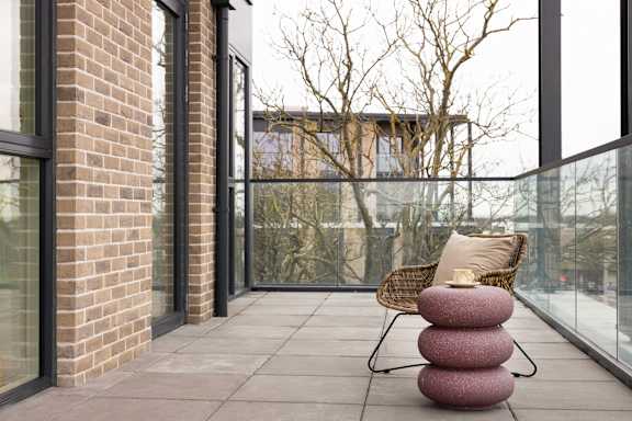 A chair with a cushion sits on a patio.
