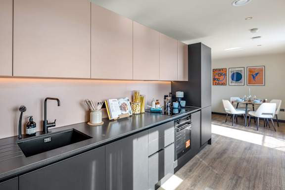 Kitchen with long worktop sink and appliances.