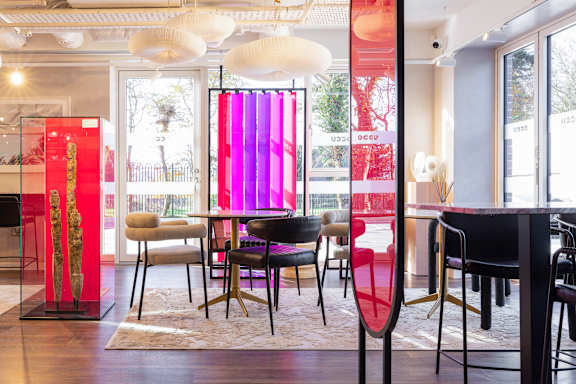 A room with a table and chairs and a red and pink curtain.