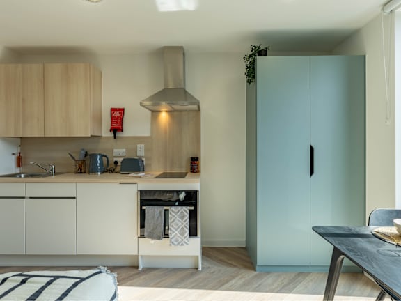 Floor Plan  a kitchen with white cabinets and a blue refrigerator