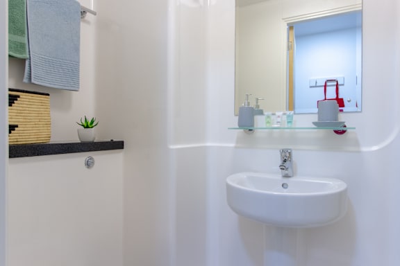 Floor Plan  a white bathroom with a sink and a mirror